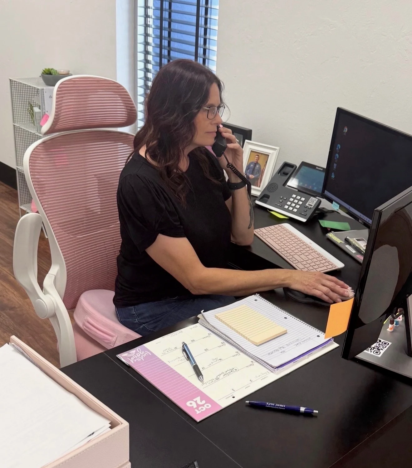 A member of our team taking a call at her desk in the Lawton office