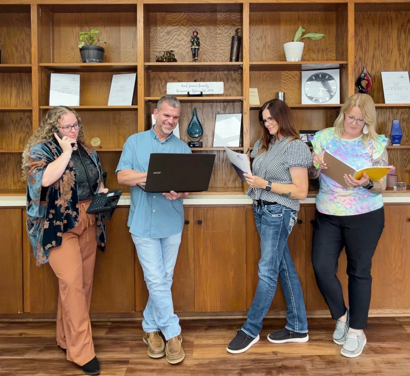 Our four-person team with a phone, laptop, and documents in the Lawton office